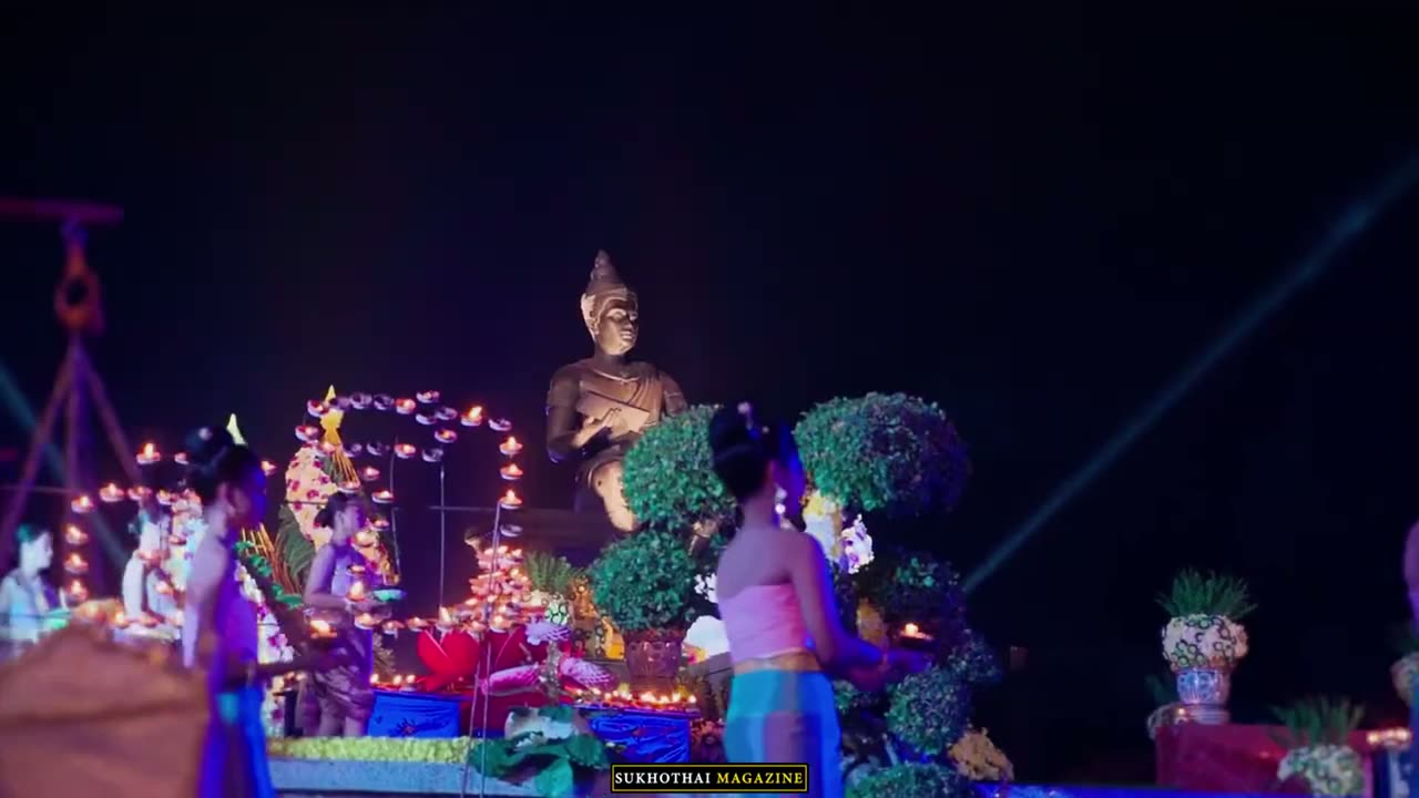 กระทงใหญ่ประดับไฟและดอกไม้ ตั้งอยู่กลางงานยามค่ำ